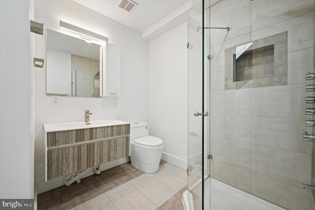bathroom featuring toilet, a shower stall, and vanity