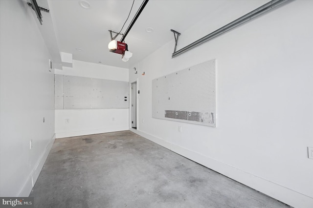 garage featuring a garage door opener and baseboards
