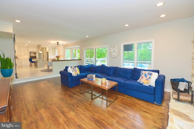 living area with recessed lighting, wood finished floors, and baseboards