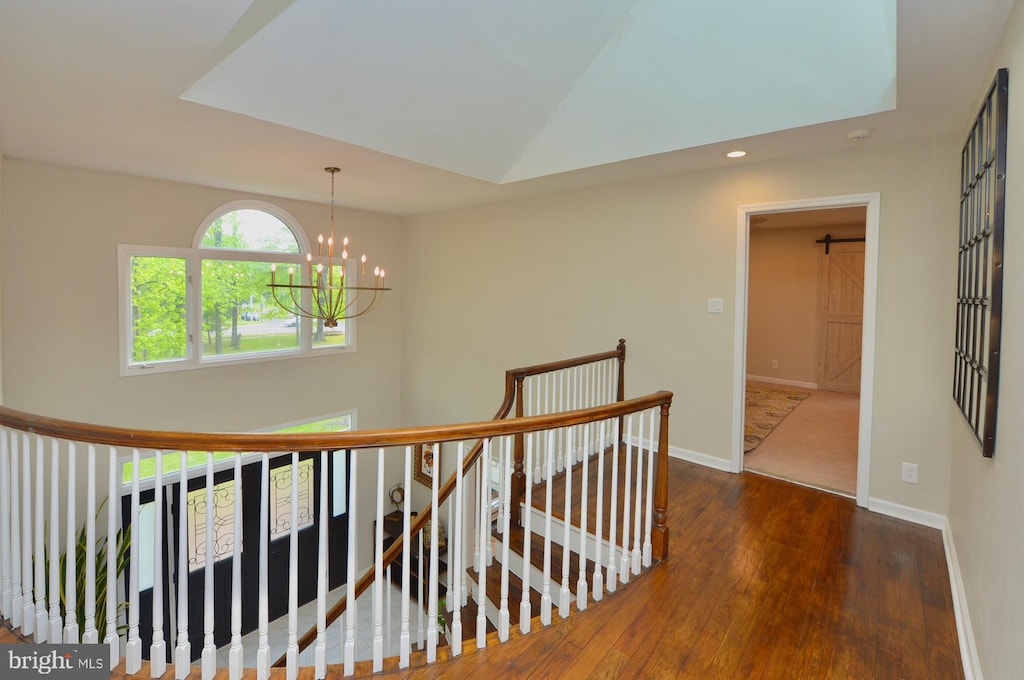 hallway featuring an upstairs landing, a chandelier, wood finished floors, baseboards, and recessed lighting