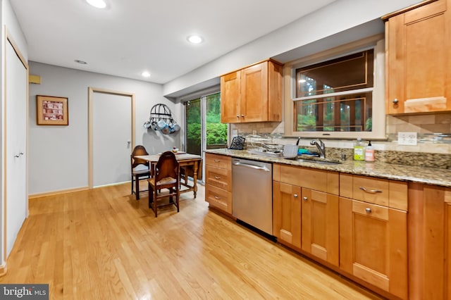 kitchen with stainless steel dishwasher, a sink, backsplash, light wood-type flooring, and recessed lighting