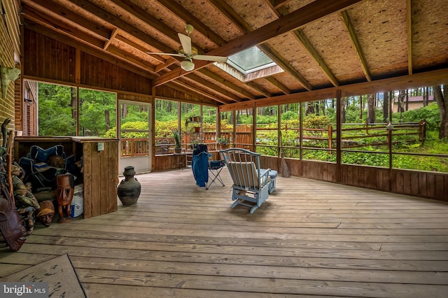unfurnished sunroom with a skylight, vaulted ceiling, and a ceiling fan