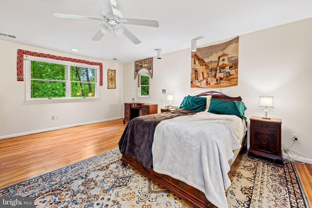 bedroom featuring wood finished floors, baseboards, and a ceiling fan