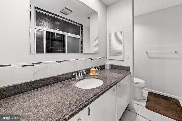 bathroom featuring a stall shower, vanity, toilet, marble look tile flooring, and baseboards