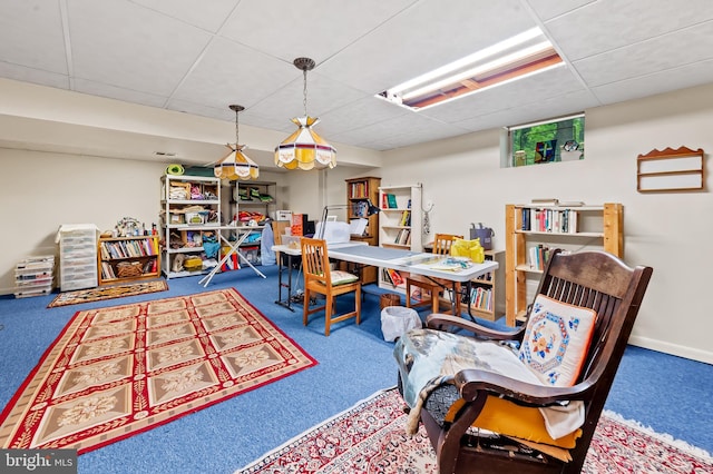 dining area featuring a paneled ceiling and carpet flooring