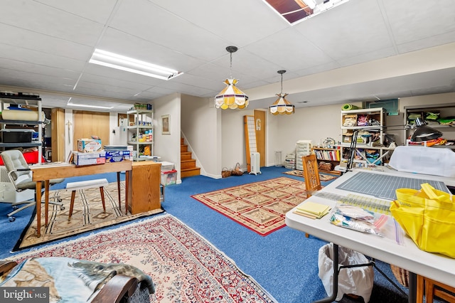 carpeted living room with stairway, a drop ceiling, and baseboards