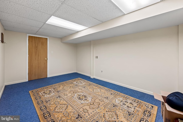 finished basement featuring carpet, baseboards, and a drop ceiling