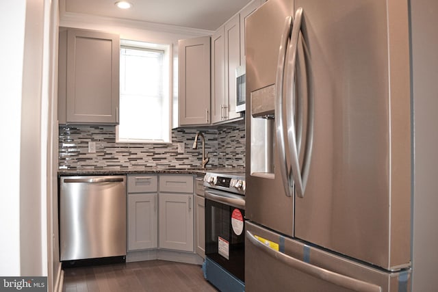1406 S 28th St, Philadelphia, PA 19146 - kitchen featuring stainless steel appliances, a sink, decorative backsplash, wood finished floors, and crown molding