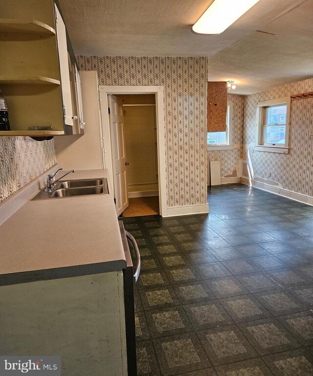 49 Front St, Wyoming, DE 19934 - kitchen featuring wallpapered walls, range, open shelves, a textured ceiling, and white cabinetry