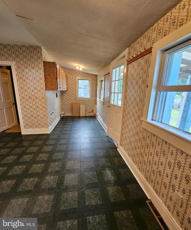 49 Front St, Wyoming, DE 19934 - spare room with wallpapered walls and dark flooring