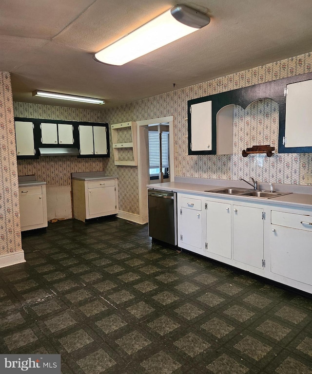 49 Front St, Wyoming, DE 19934 - kitchen with wallpapered walls, dishwasher, white cabinetry, under cabinet range hood, and light countertops