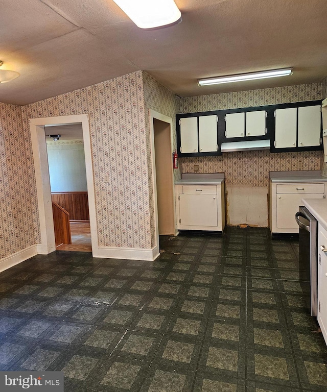 49 Front St, Wyoming, DE 19934 - kitchen with wallpapered walls, white cabinetry, light countertops, dishwasher, and a textured ceiling