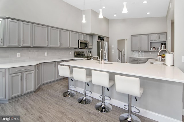 3302 Olympia Ave, Baltimore, MD 21215 - kitchen featuring gray cabinetry, a sink, stainless steel appliances, tasteful backsplash, and a towering ceiling