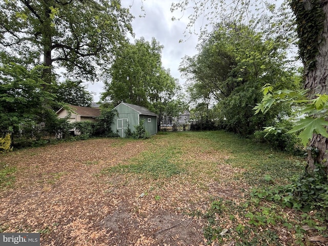 view of yard with a storage unit, an outbuilding, and fence