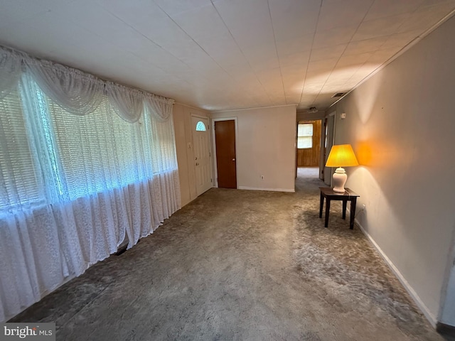 carpeted empty room featuring baseboards