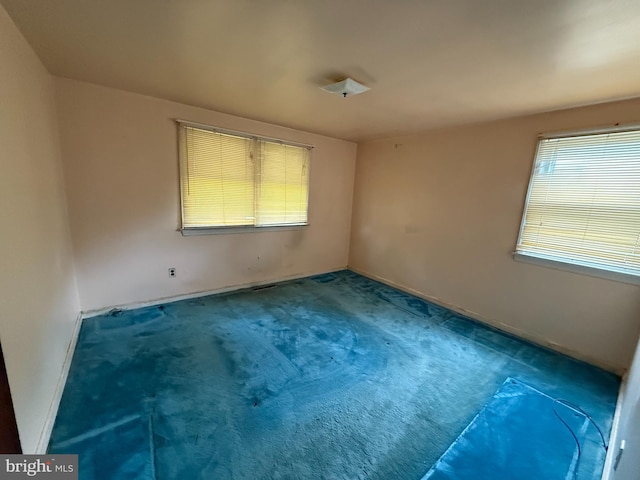 empty room featuring carpet floors and baseboards