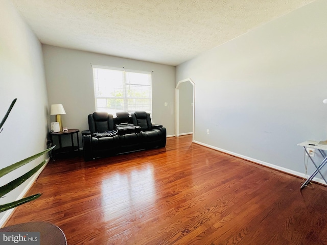 10400 Markby Ct, White Plains, MD 20695 - living room featuring arched walkways, a textured ceiling, wood finished floors, and baseboards