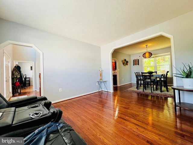 10400 Markby Ct, White Plains, MD 20695 - living area featuring arched walkways, wood finished floors, and baseboards