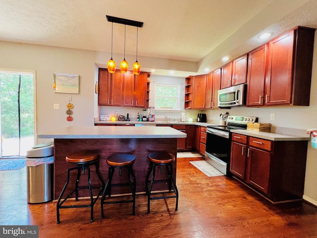 10400 Markby Ct, White Plains, MD 20695 - kitchen featuring stainless steel appliances, open shelves, a breakfast bar area, wood finished floors, and hanging light fixtures