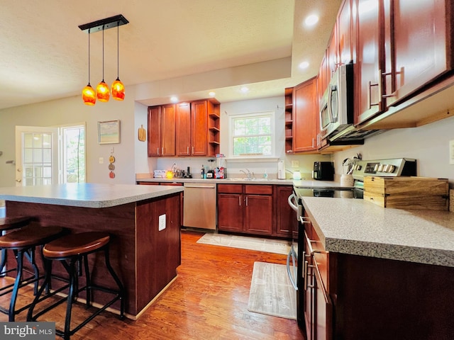 10400 Markby Ct, White Plains, MD 20695 - kitchen with stainless steel appliances, open shelves, light wood finished floors, a kitchen bar, and a sink