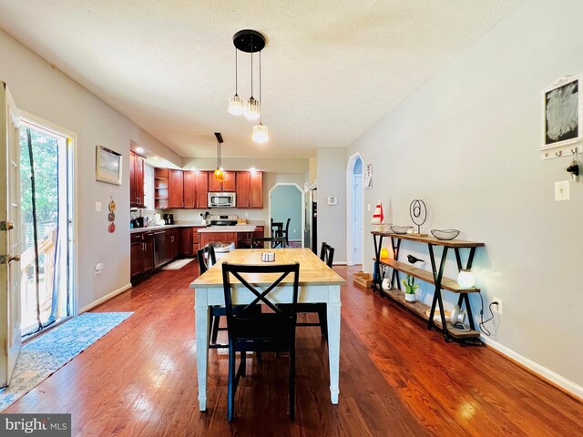 10400 Markby Ct, White Plains, MD 20695 - dining room featuring arched walkways, dark wood-type flooring, and baseboards
