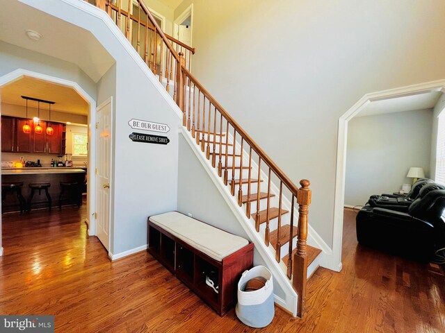 10400 Markby Ct, White Plains, MD 20695 - stairway featuring wood finished floors, baseboards, and arched walkways