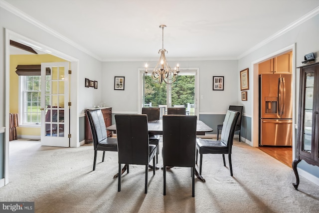 24749 Swan Rd, Saint Michaels, MD 21663 - dining space with light colored carpet, a chandelier, plenty of natural light, crown molding, and baseboards