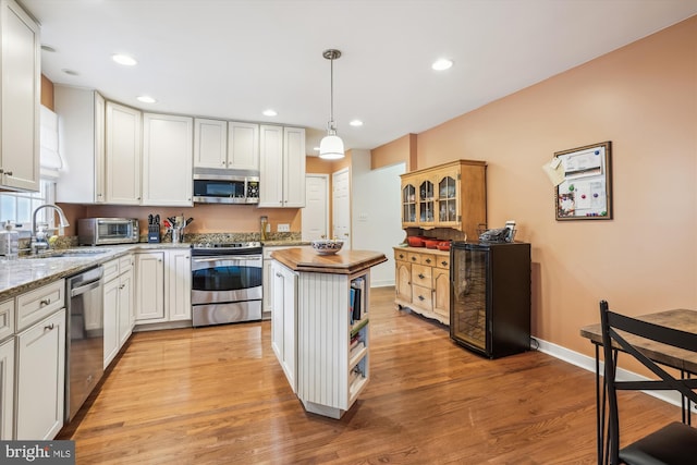 24749 Swan Rd, Saint Michaels, MD 21663 - kitchen with appliances with stainless steel finishes, a sink, light wood-style floors, a center island, and recessed lighting