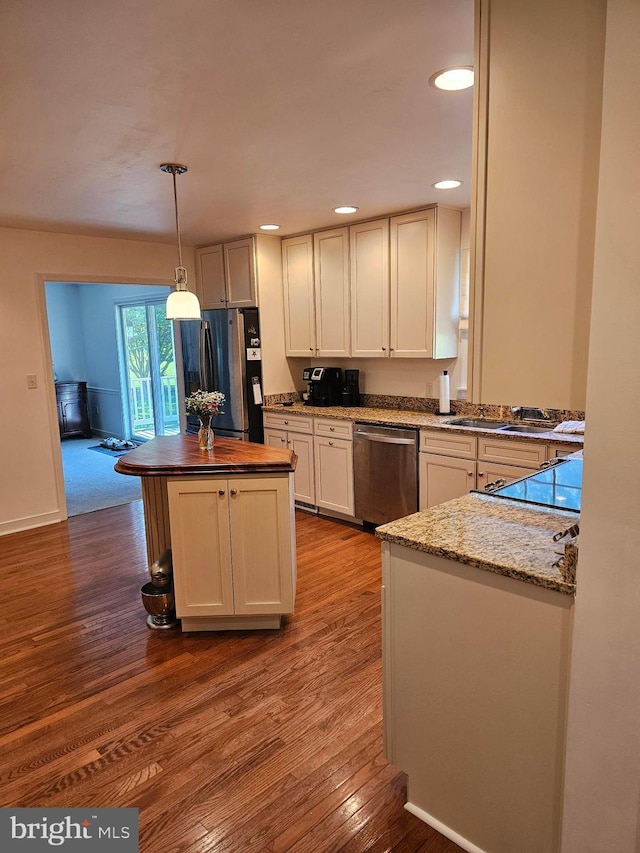 24749 Swan Rd, Saint Michaels, MD 21663 - kitchen featuring appliances with stainless steel finishes, dark wood-style floors, a kitchen island, decorative light fixtures, and butcher block counters