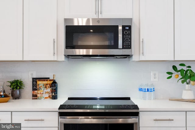 kitchen featuring appliances with stainless steel finishes, white cabinets, light countertops, and tasteful backsplash