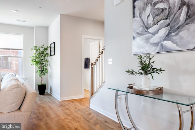 hall with light wood-style flooring and baseboards