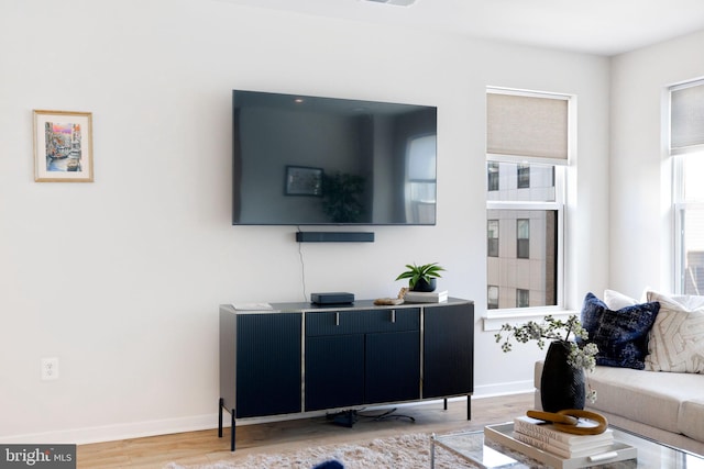 living area featuring light wood-style floors and baseboards
