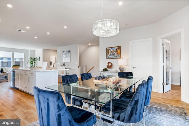 dining area with light wood finished floors, recessed lighting, a chandelier, and baseboards