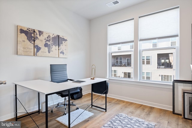 office space with light wood-type flooring and baseboards