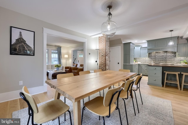 dining space featuring light wood-style flooring and baseboards