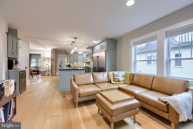 living room with light wood-style floors, wine cooler, and recessed lighting