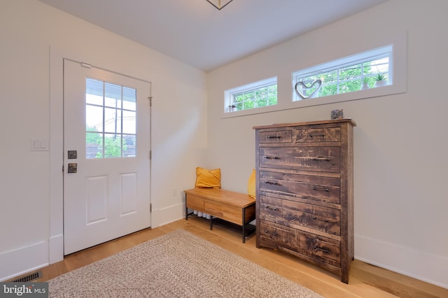 doorway featuring light wood-type flooring and baseboards