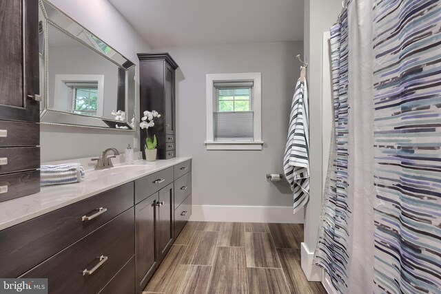bathroom featuring wood tiled floors, vanity, and baseboards