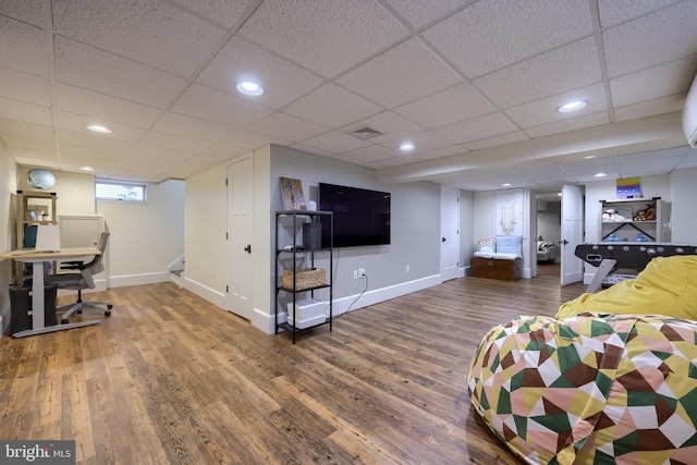 living room with wood finished floors, baseboards, stairs, recessed lighting, and a drop ceiling
