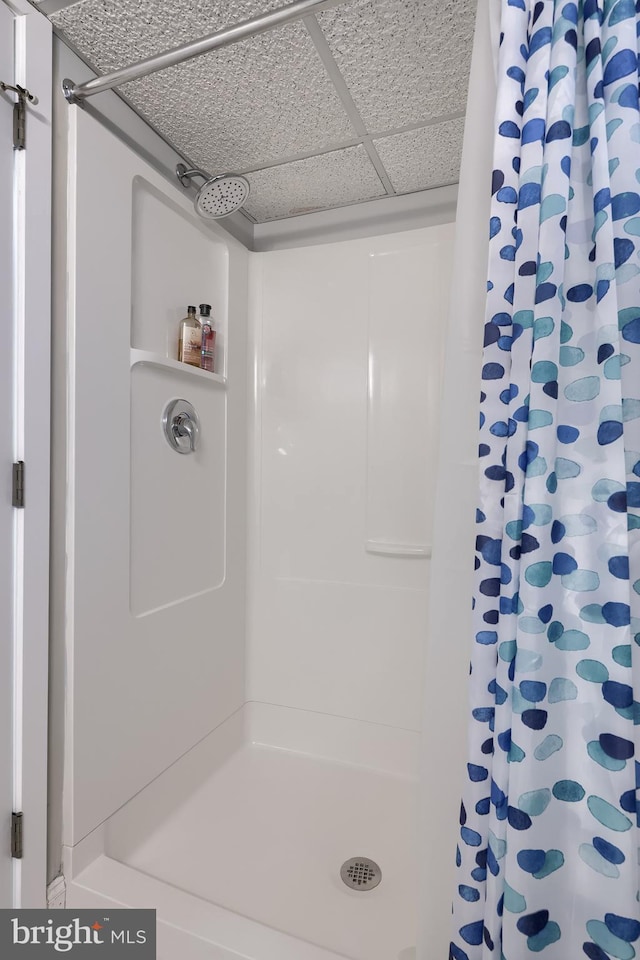 full bath featuring a stall shower and a paneled ceiling