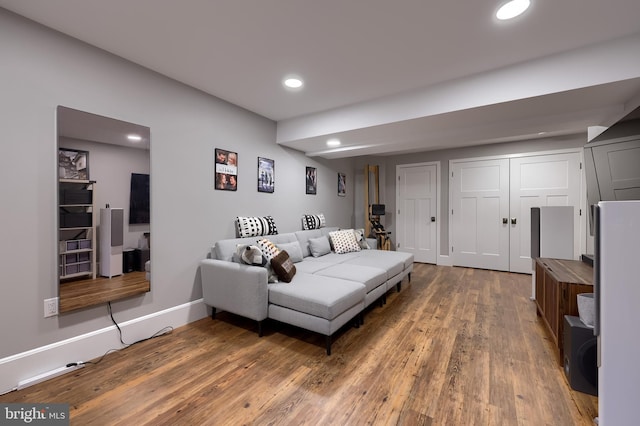 living room featuring wood finished floors, recessed lighting, and baseboards