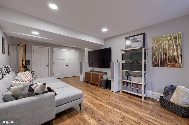 living room featuring light wood finished floors, baseboards, and recessed lighting