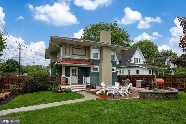 rear view of property featuring a standing seam roof, a chimney, metal roof, and a patio