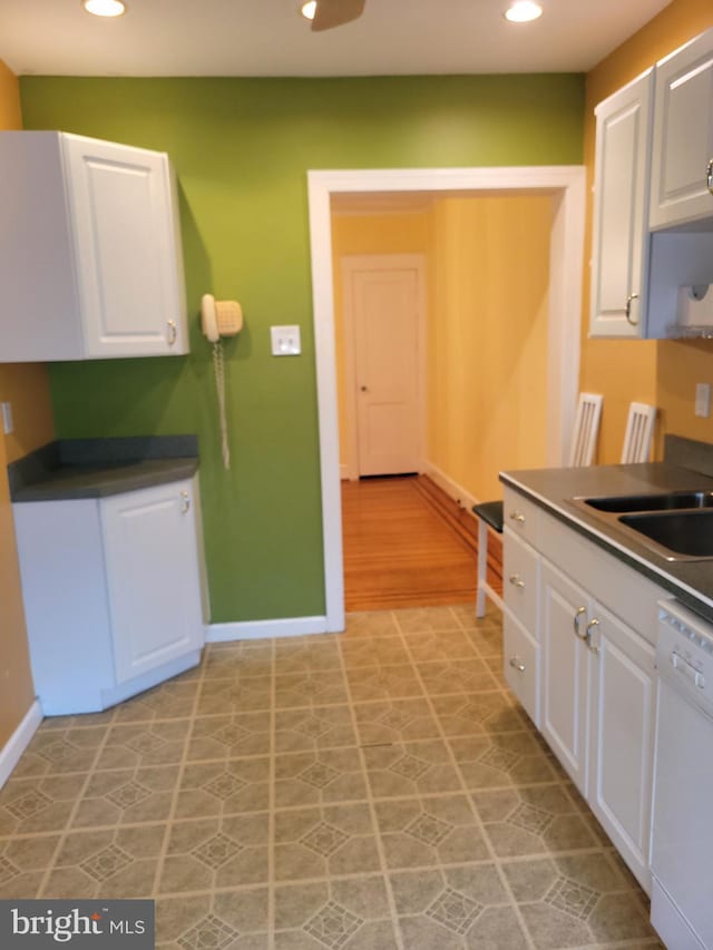 kitchen with white dishwasher, white cabinetry, baseboards, and recessed lighting