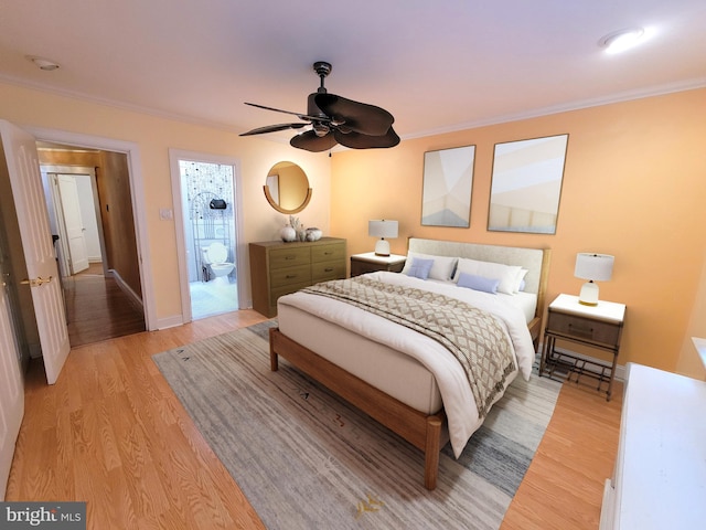 bedroom with light wood-style flooring, crown molding, baseboards, and connected bathroom