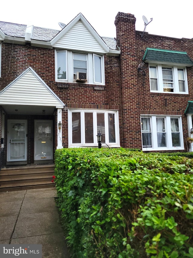 view of property with brick siding and a high end roof