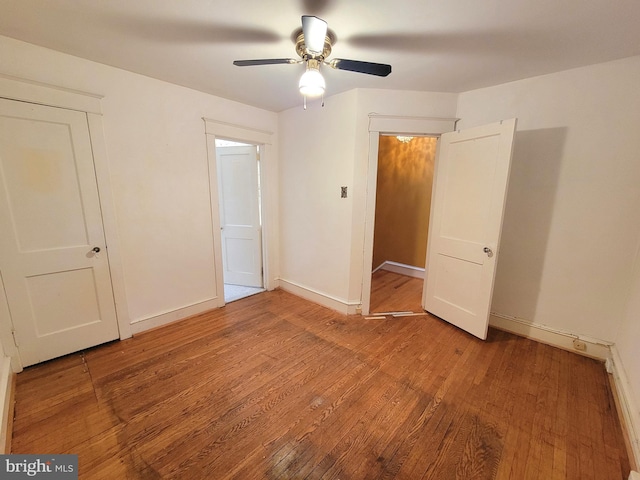 unfurnished bedroom featuring wood-type flooring, baseboards, and ceiling fan