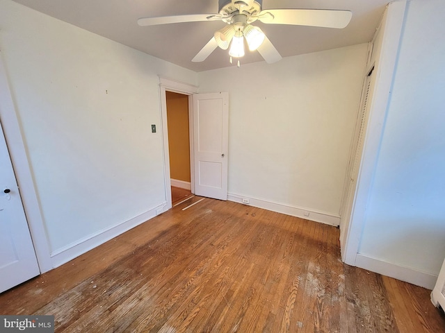 unfurnished bedroom with wood finished floors, baseboards, a ceiling fan, and a closet