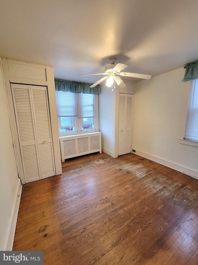 unfurnished bedroom with radiator, wood finished floors, baseboards, and a ceiling fan
