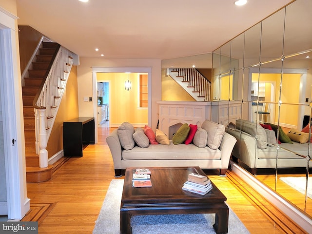 living room with stairs, light wood-style flooring, recessed lighting, and baseboards